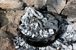 Dutch oven covered by coals